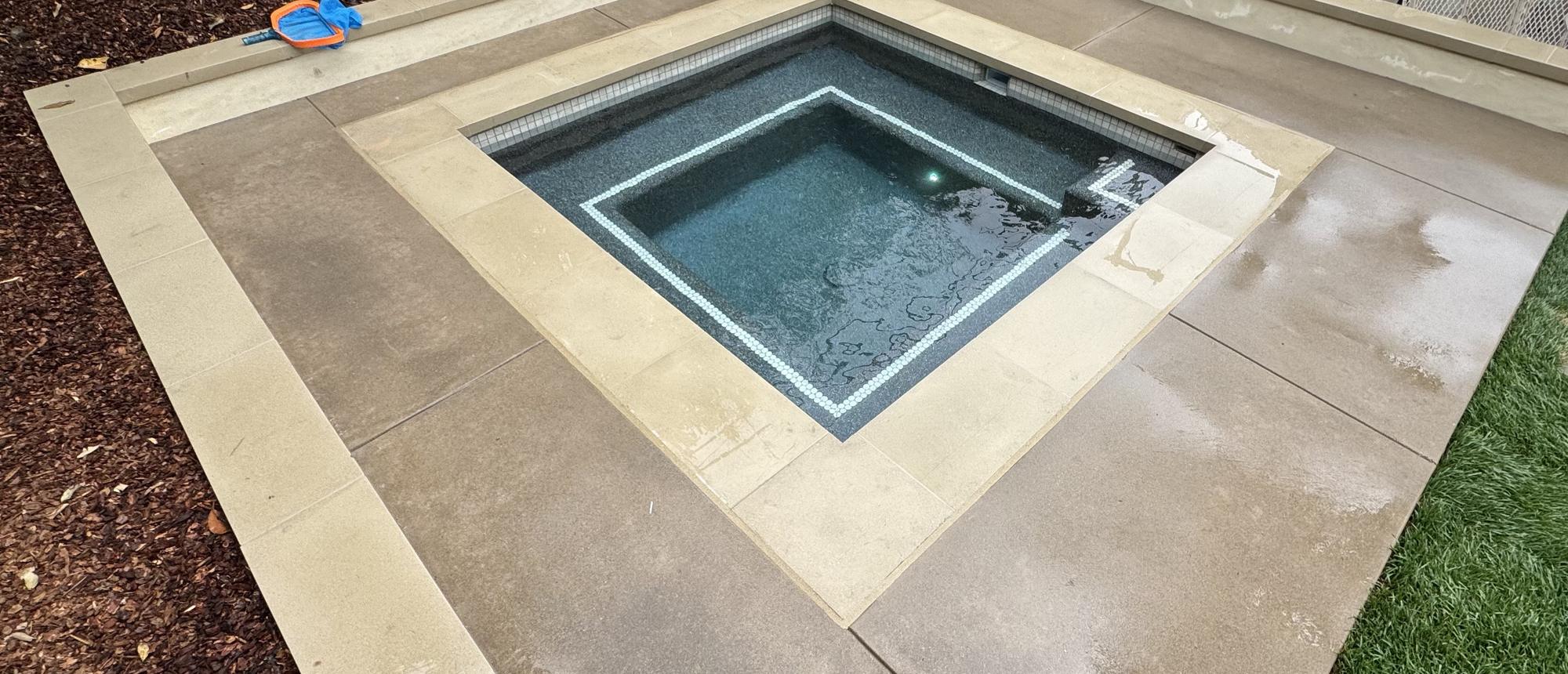 Geometric pool and flush spa with wide stone coping