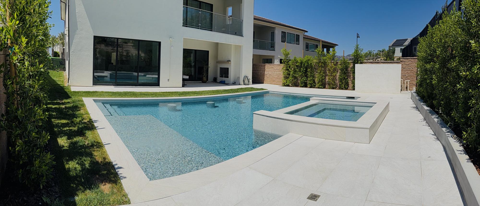 Custom pool and raised spa behind a modern home