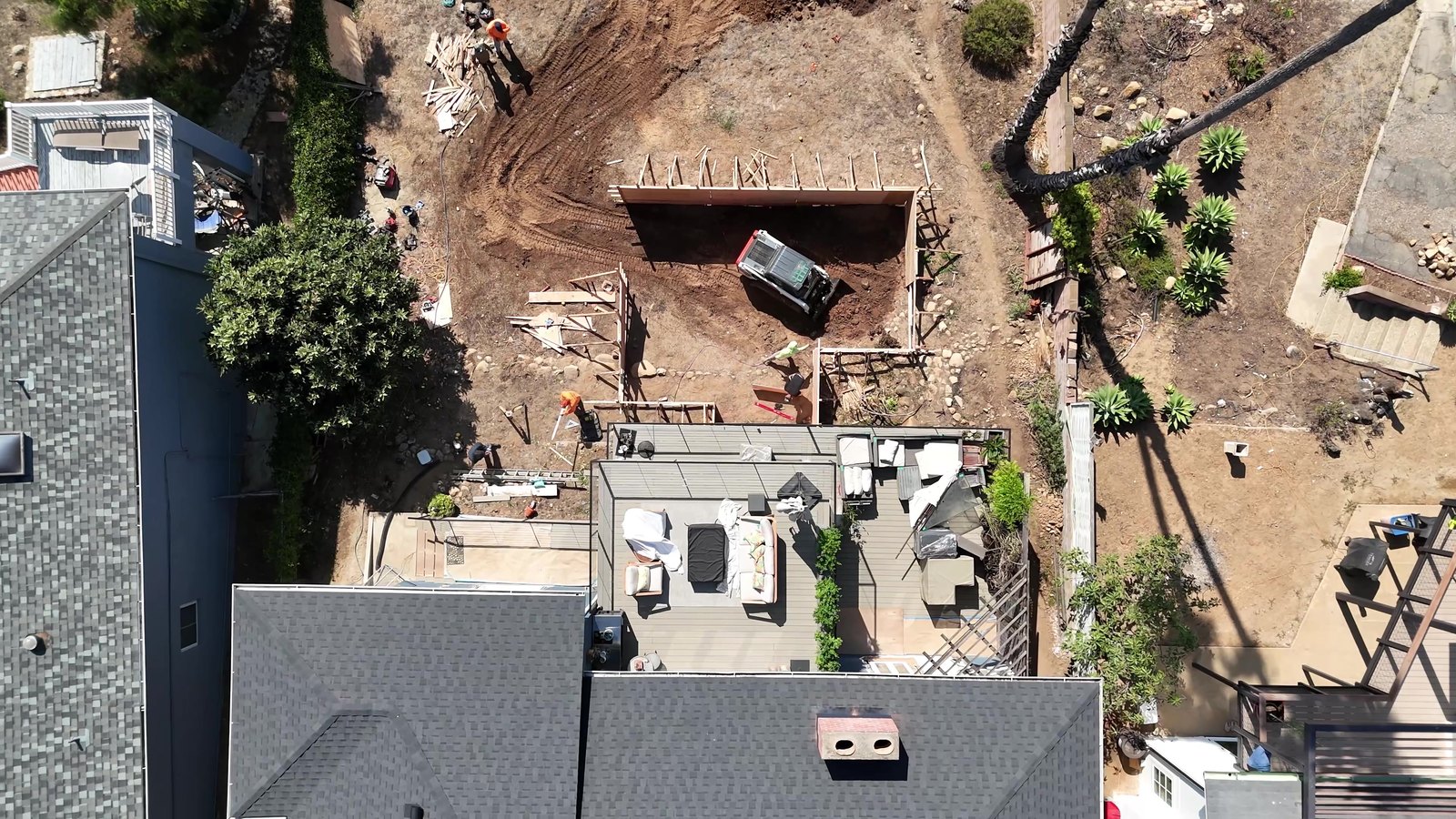 Pool excavation in progress behind a house, seen from above