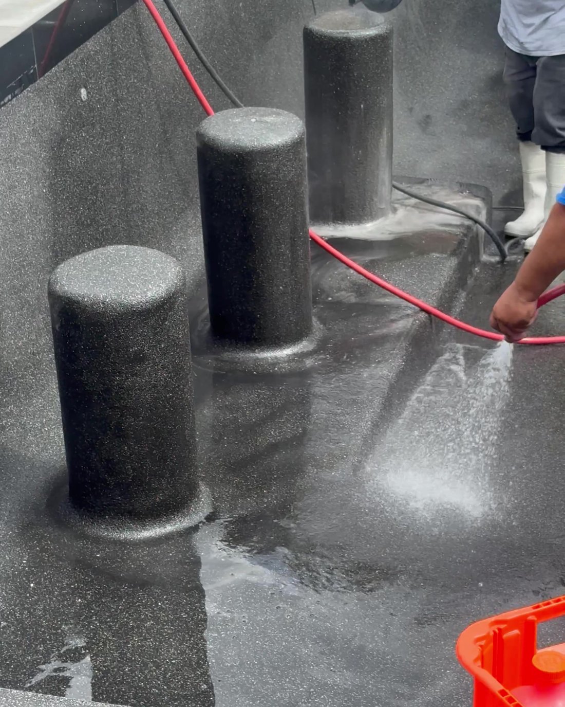 Swim-up bar stools in a fresh dark pebble finish being washed down