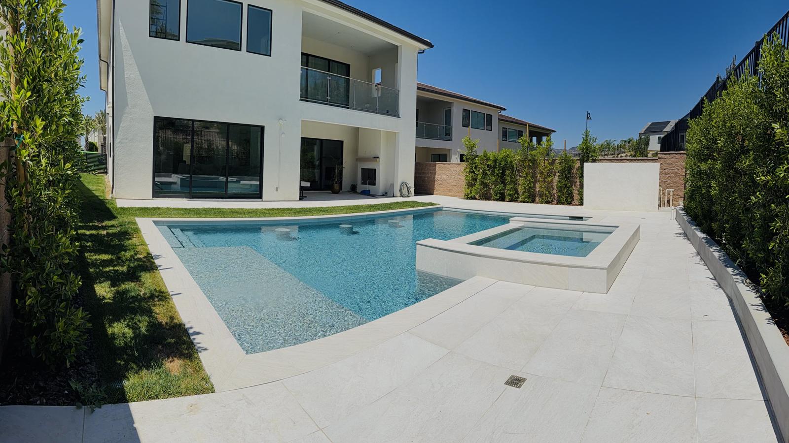 Custom pool and raised spa behind a modern home