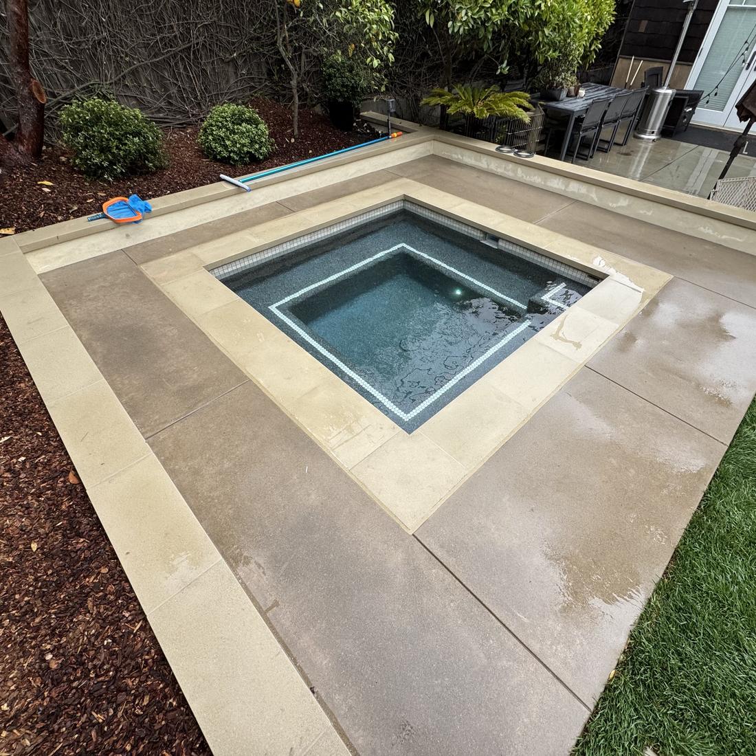 Geometric pool and flush spa with wide stone coping